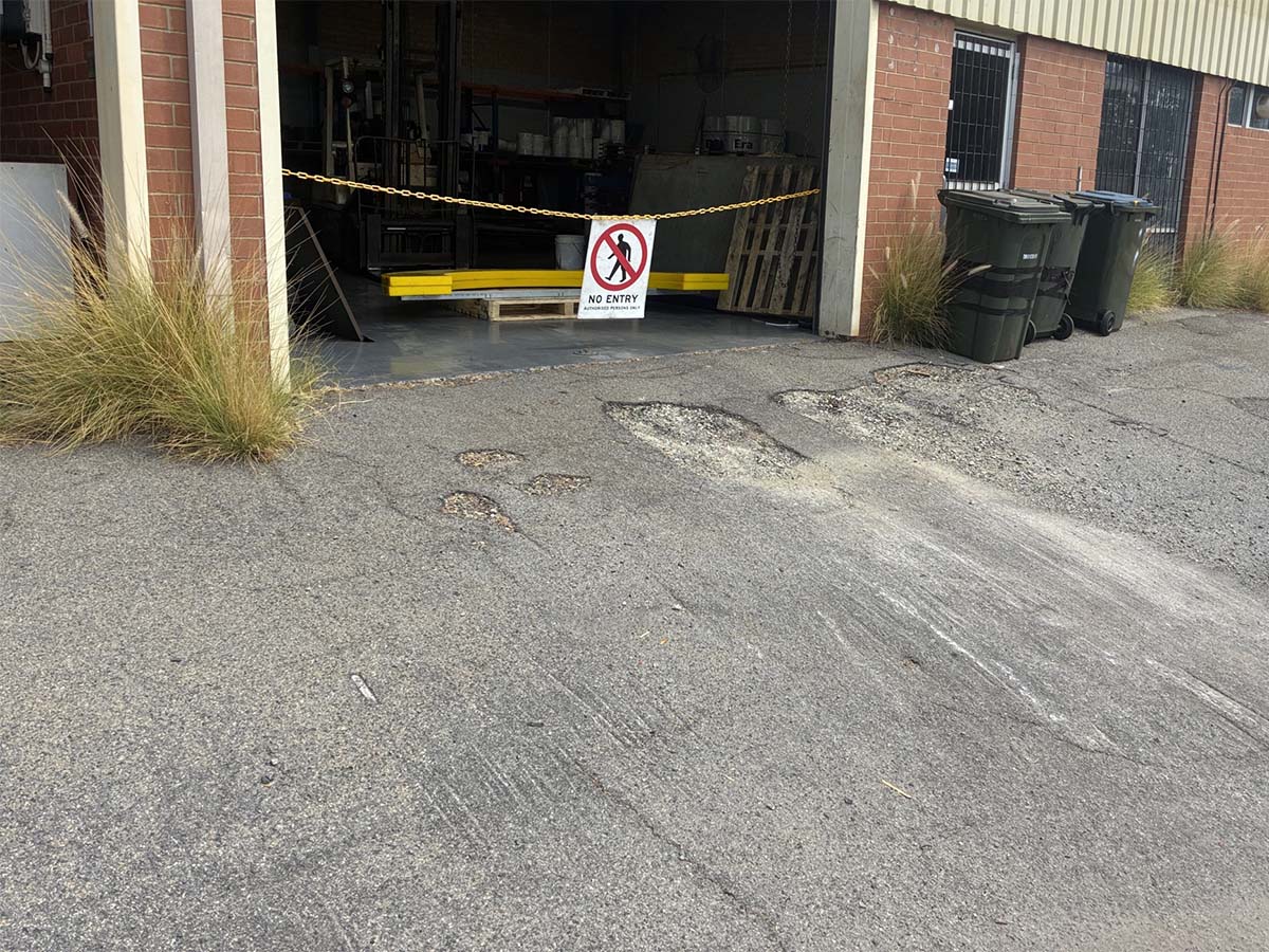 Before image of an asphalt patch repair and ramp installation in Welshpool, Western Australia for Polyrubber.